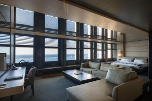 Luxury suite with harbor views in Izmir.
Spacious and modern hotel suite with large windows looking out over the sea, furnished with neutral-toned seating, a desk, and a bed.