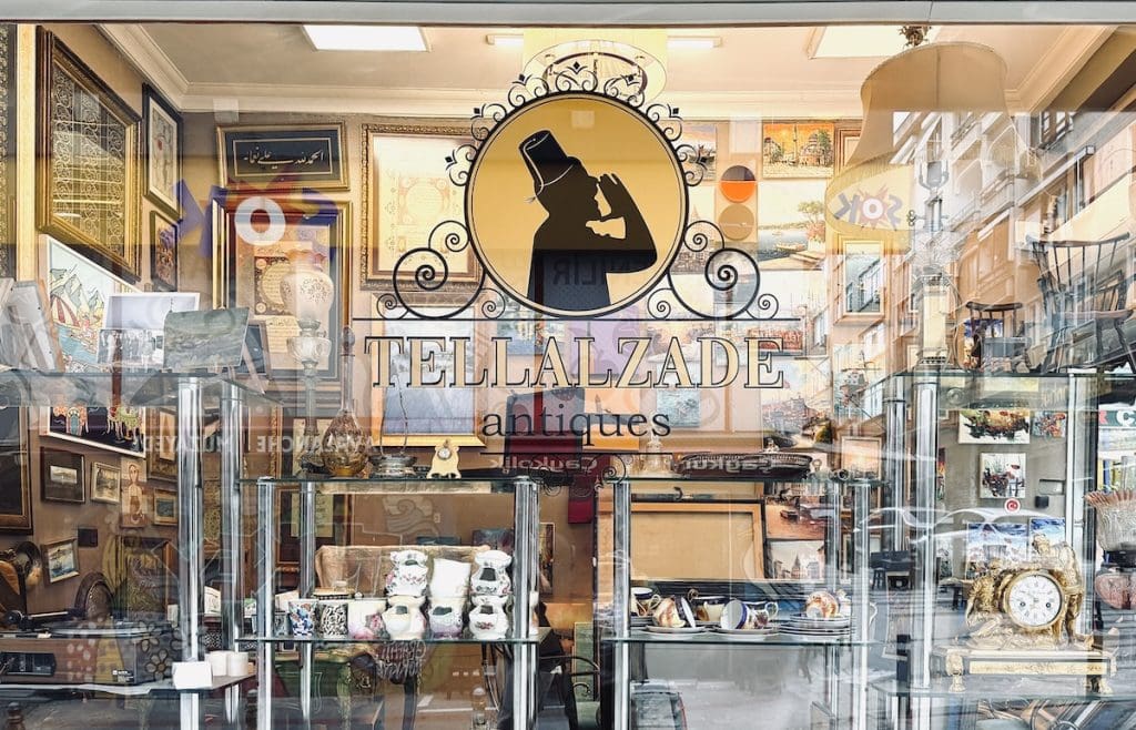 Antique shop window filled with vintage decor and artwork in a historic authentic Istanbul neighborhood.