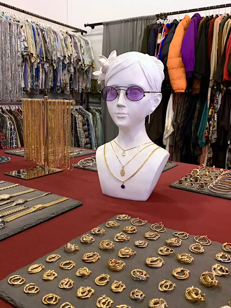 Display of gold jewelry, accessories, and vintage clothing inside a popular thrift shop in Galata.