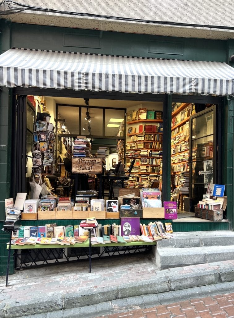 Independent secondhand bookshop in Besiktas with shelves stacked to the ceiling and books displayed outside on the steps.