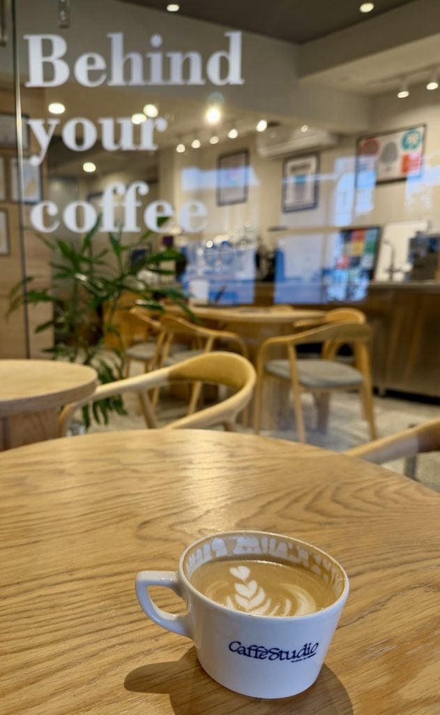 Latte on a wooden table inside a minimalist specialty coffee shop in Besiktas.