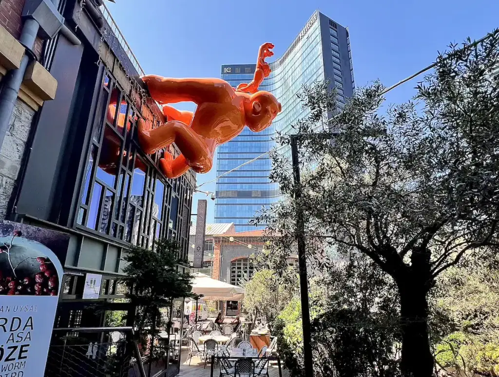 A fun, bright orange sculpture of a money mounted on a modern building in Bomonti, a trendy hipster district of Istanbul.