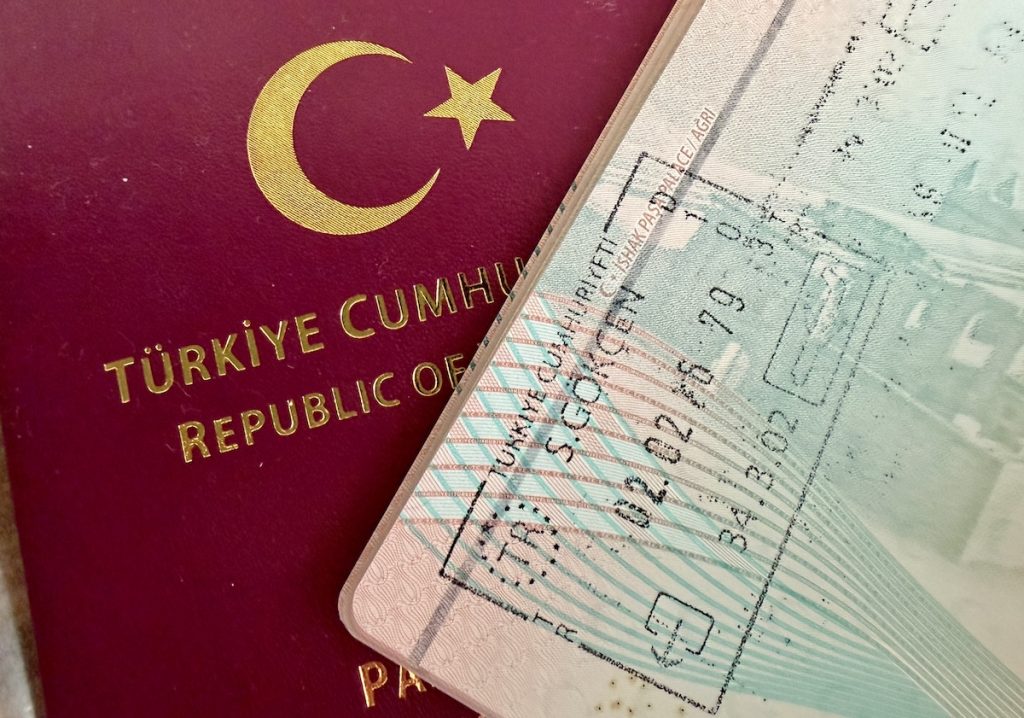 Turkish passport page with an entry stamp placed over a red passport
