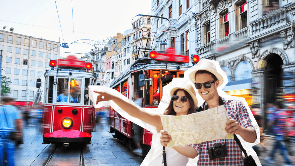 Couple holding a map and pointing down a busy street as a red historic tram passes through central Istanbul. Visiting Istiklal Street is one of the most popular things to do in Istanbul on a layover.